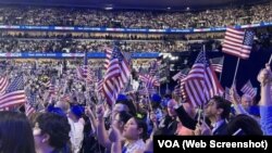 Asistentes a la Convención Nacional Demócrata 2024 ondean banderas de EEUU en el United Center de Chicago, el 22 de agosto de 2024.